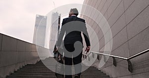 Businessman walking up the stairs in rush hour to work in office a hurry