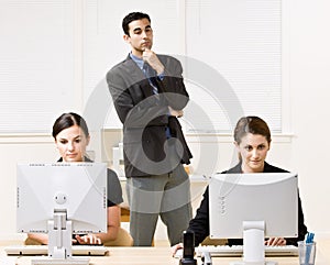 Businessman watching co-workers work