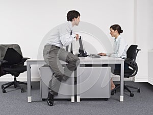 Businessman Watching Female Colleague In Office