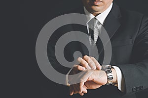 Businessman watching his wrist watch and checking time