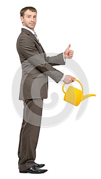 Businessman with watering-can showing ok