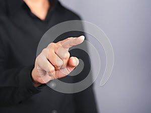 Businessman wearing a black shirt is pointing to touching the virtual screen.