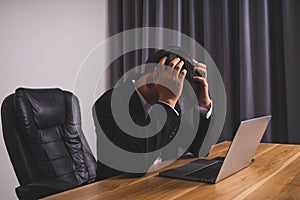 Businessman wearing black suit sitting stressed