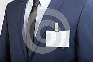 Businessman wearing a blank ID tag or name card during an exhibition or a conference