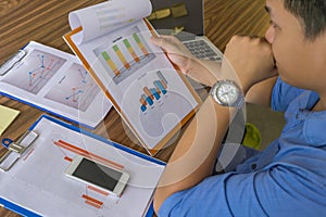 Businessman wearing blue shirt reading report in the office