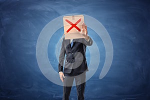 Businessman is wearing cardboard box with drawn red cross sign