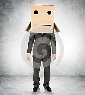 Businessman wearing carton box with drawn emotions