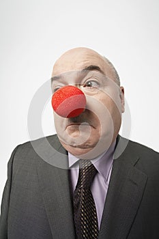 Businessman Wearing Clown Nose Frowning
