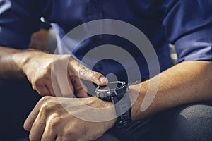 Businessman wearing digital smart watch in hand