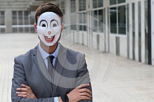 Businessman wearing a disturbing mask with arms crossed