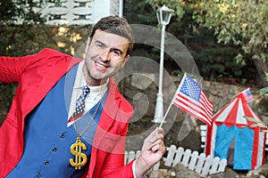 Businessman wearing dollar sign necklace holding US flag