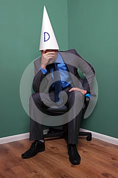 Businessman wearing a dunce hat