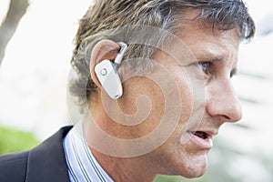 Businessman wearing earpiece outdoors