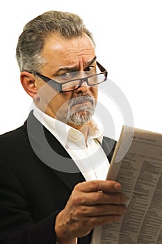 Businessman wearing glasses holds a newspaper.