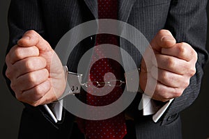 Businessman Wearing Handcuffs Illustrating Corporate Crime