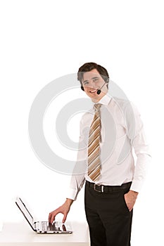 Businessman wearing a headset at his laptop