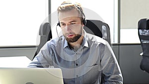 Businessman wearing headset working in office to support remote customer or colleague.