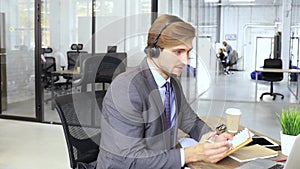 Businessman wearing headset working in office to support remote customer or colleague.