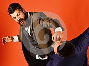 Businessman wearing smart suit punches or hits colleague.