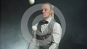 Businessman wearing a suit juggling white balls. Success and management