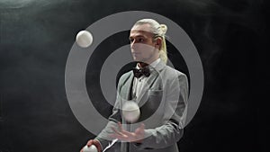 Businessman wearing a suit juggling white balls. Success and management