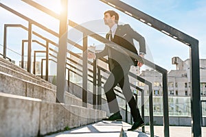 Businessman wearing suit running up the stairs