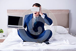 The businessman wearing a virtual reality headset in the bedroom