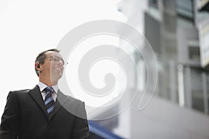 Businessman Wearing Wireless Headset Against Sky