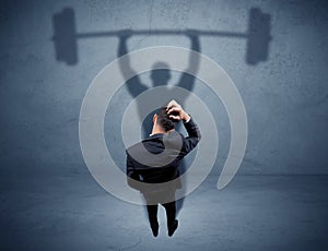 Businessman with weight lifting shadow