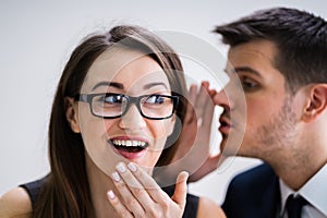 Businessman Whispering Into Female Partner`s Ear