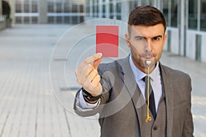 Businessman with whistle and red card