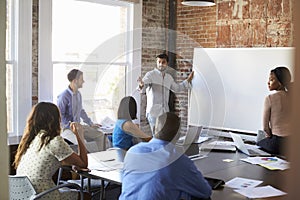 Businessman At Whiteboard In Brainstorming Meeting