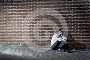 Businessman who lost job lost in depression sitting on city street corner