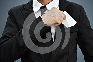 businessman who takes out white piece of paper from the pocke