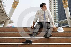 Businessman who are tired or stressed sitting alone on stairs