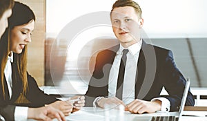 Businessman and woman with colleague sitting and working at the desk. Business people discussing questions at meeting in