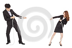 Businessman and woman playing tug of war