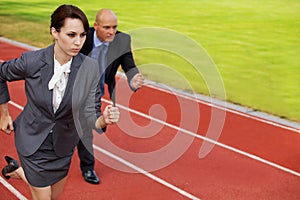 Businessman and woman on running on race track
