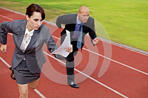 Businessman and woman on running on race track