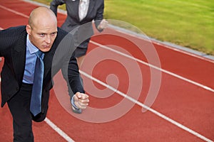 Businessman and woman on running on race track