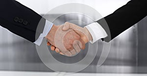 Businessman and woman shaking hands in office. Concept of handshake as success symbol in business