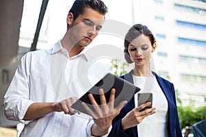 Businessman and woman using mobile phone and digital tablet