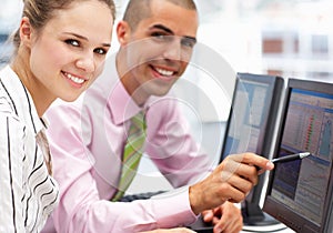 Businessman and woman working on computers