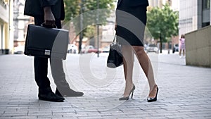 Businessman and woman talking on street, fashionable classic shoes and briefcase