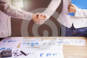 Businessman and women together create a mutually beneficial business relationship. Economic graph on the table