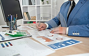 businessman work alone with business document graph and statistic with computer at office.