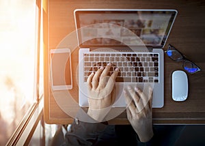 Businessman at work. Close-up top view of man working on laptop while sitting at the wooden desk