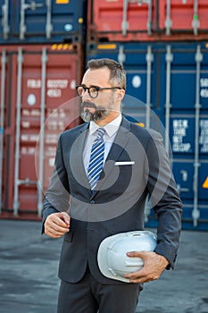 Businessman  work at Container cargo site check up goods in container. Manager checking on shipping containers. Logistics and ship