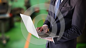 businessman work on laptop in factory