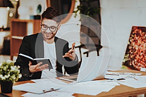 Businessman Work on Laptop Looking at Notepad